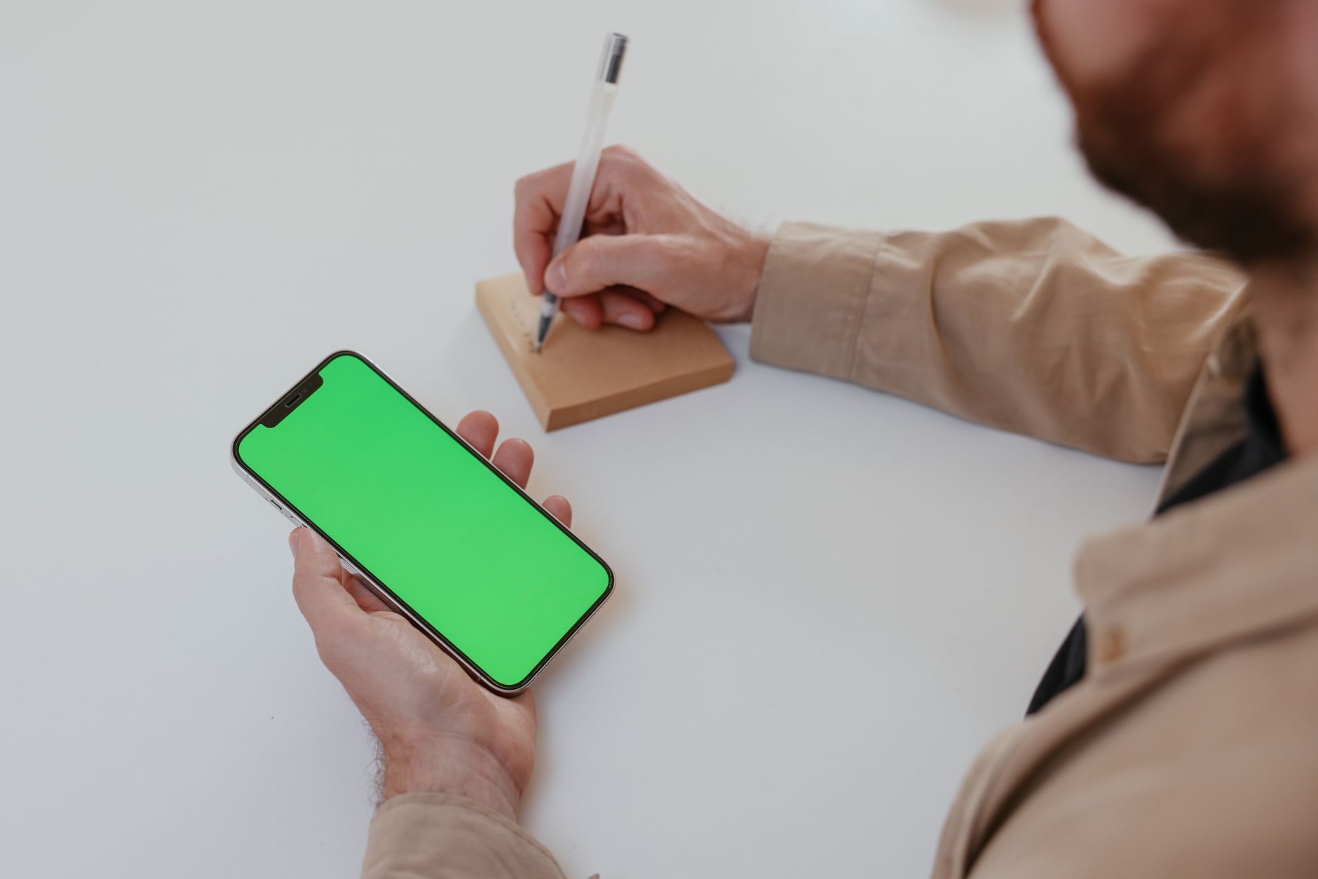 手書きメモや名刺をスマホで撮影する経営者