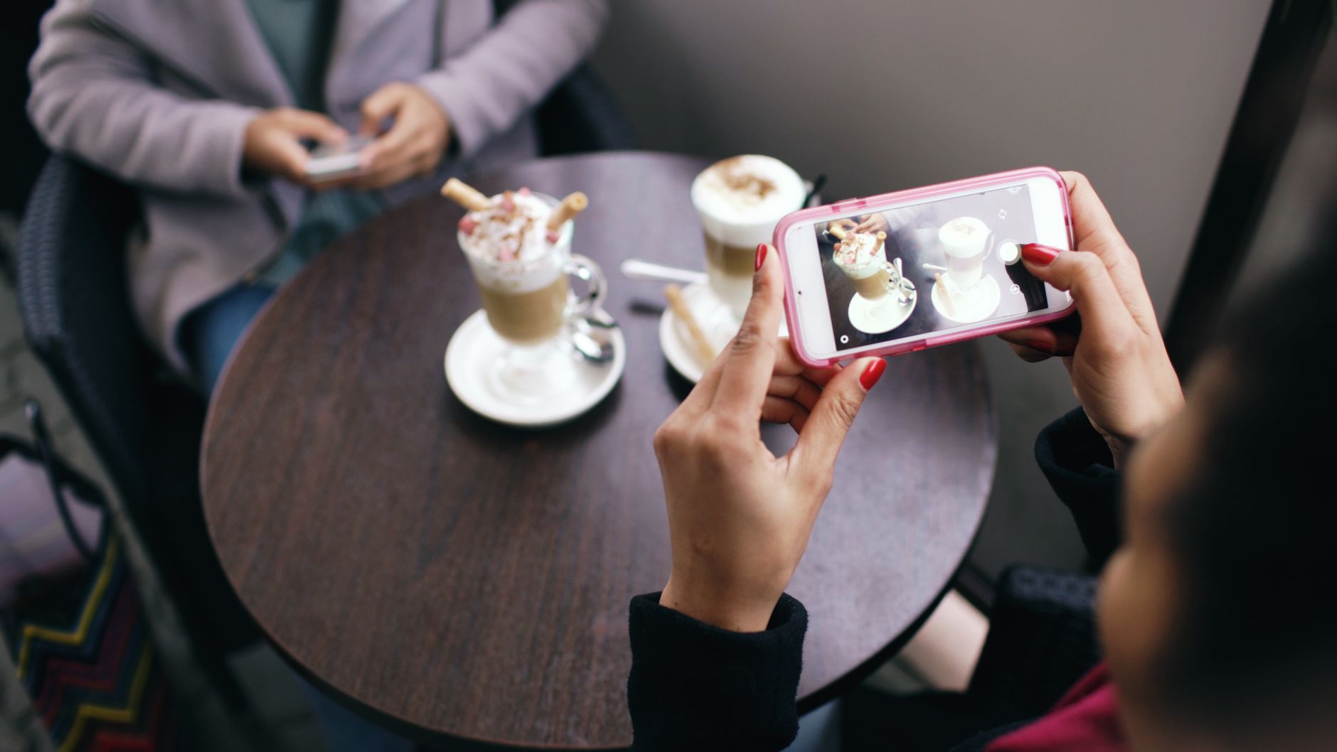 スマートフォンで料理を撮影しSNS投稿を準備する店主